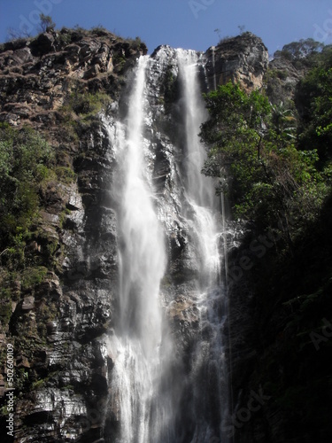 high waterfall amid very green