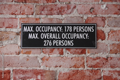 MAX. OCCUPANCY sign on an old building inside brick wall © Jack