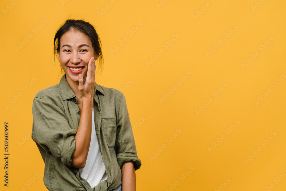 Young Asia lady with positive expression, smile broadly, dressed in casual clothing and looking at camera over yellow background. Happy adorable glad woman rejoices success. Facial expression concept. Young Asia lady with positive expression, smile broadly, dressed in casual clothing and looking at camera over yellow background. Happy adorable glad woman rejoices success. Facial expression concept.