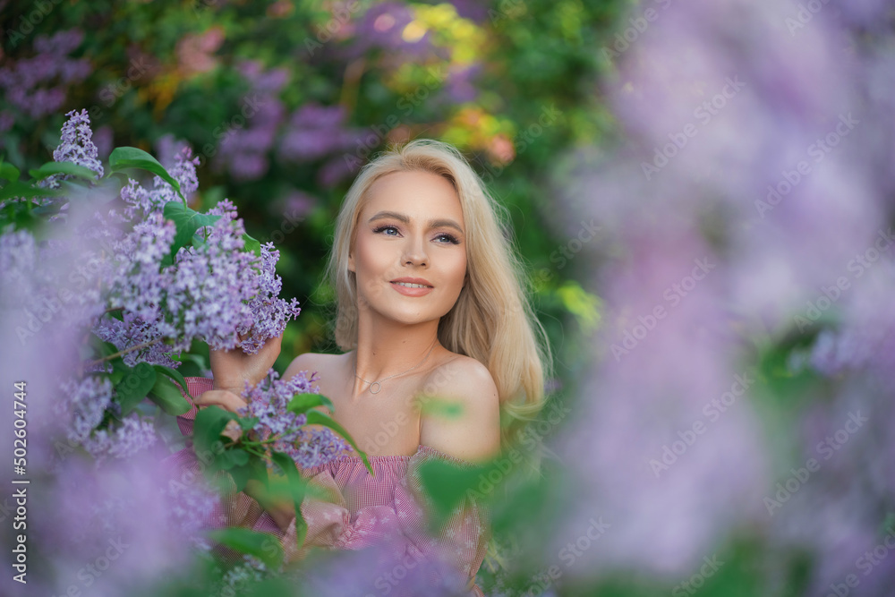 gentle, beautiful girl in a pink top among lilac flowers gentle, beautiful girl in a pink top among lilac flowers