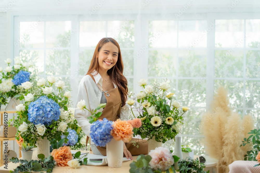 Portrait of happiness young Asia Female florist making flower vase for customers in floral retail shop.Small business of Flower design store,arranging flowers,work from home business concept.