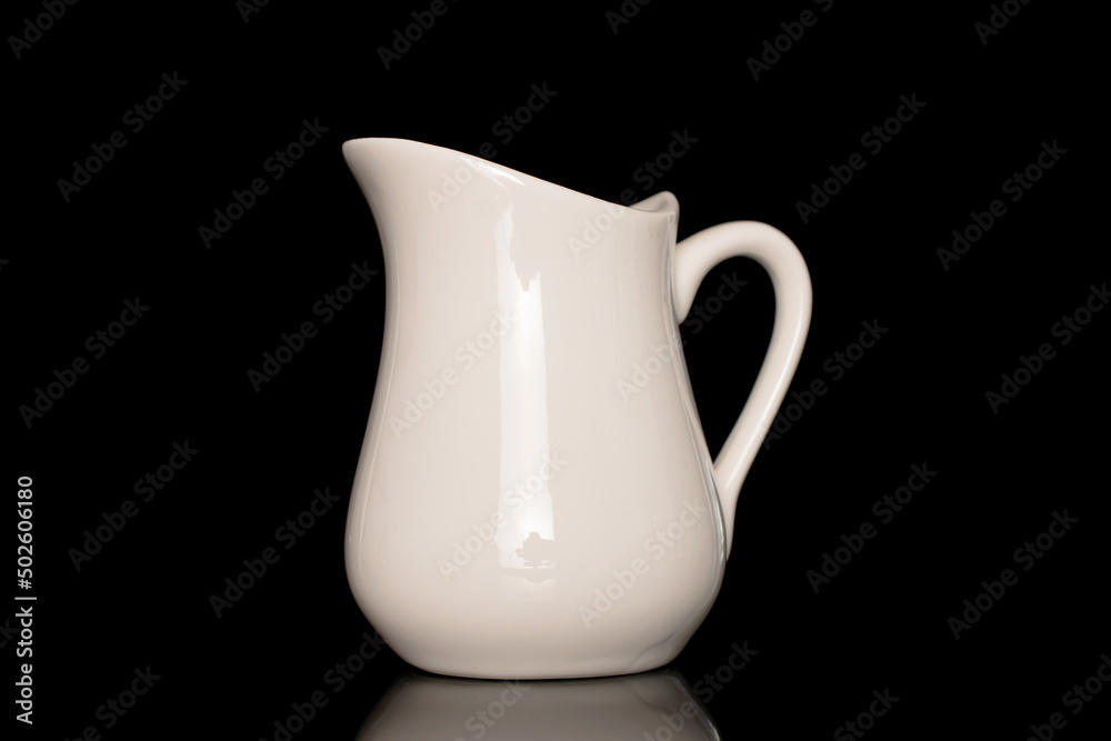 One ceramic milk jug, close-up, isolated on a black background. Stock Photo  | Adobe Stock