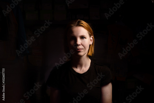 A woman of forty years old without cosmetics on a black background.