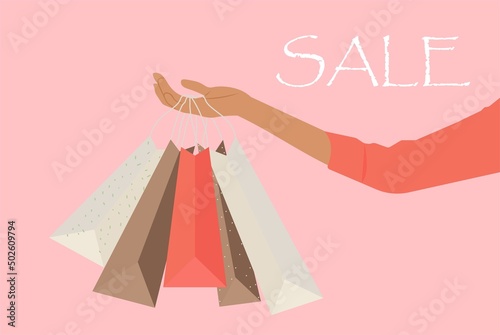 A woman's hand holding shopping bags sale