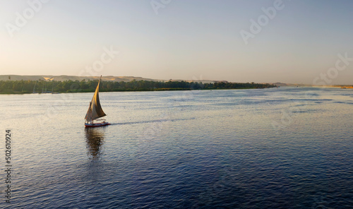 Egypt, Aswan, Panoramic view of felucca sailing down Nile River at sunset