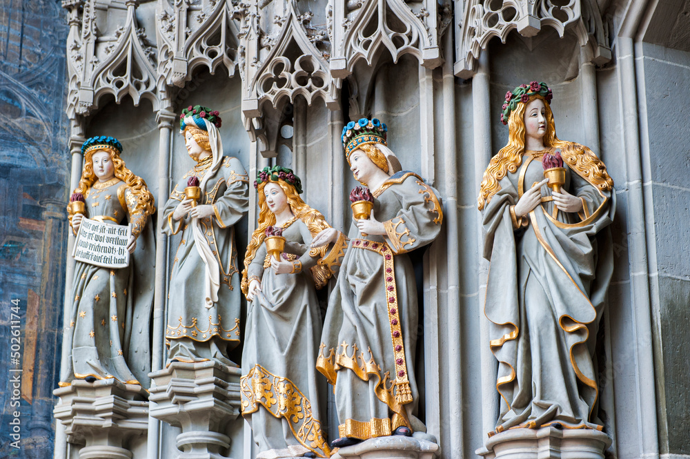 Obraz premium Statues outside the main door of the Muenster of Berne (German: Berner Muenster) of the Gothic cathedral (or minster) in the old city of Berne, Switzerland