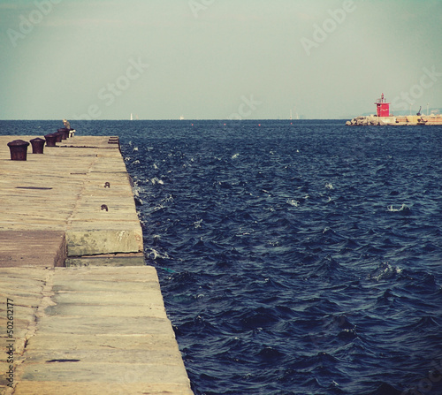 Trieste, Italy- walking along Audace pier in a sunny and windy day photo
