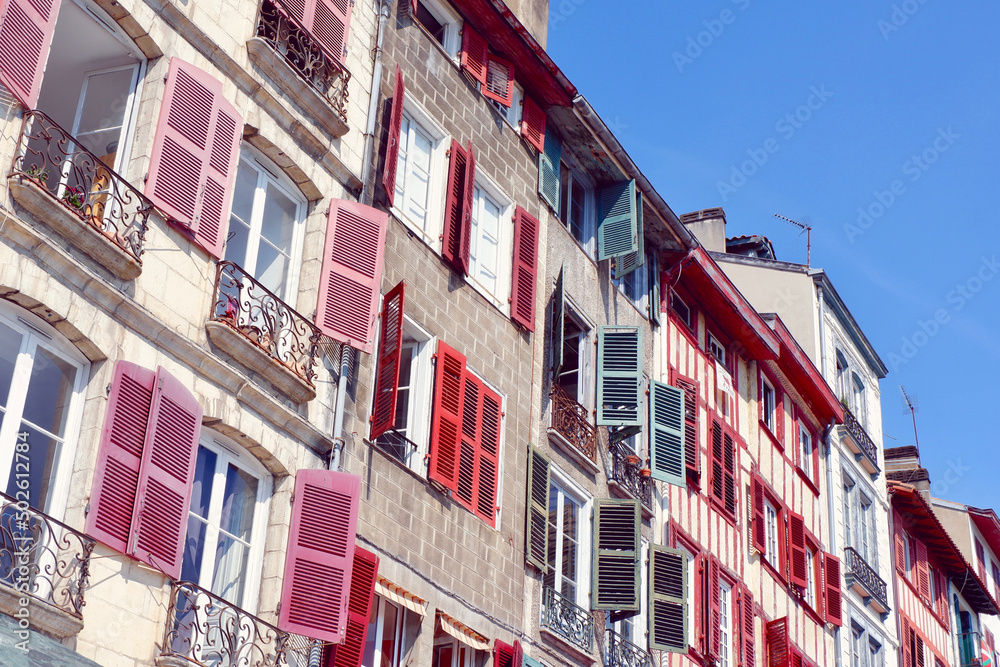 Classical colourful facades in Bayonne, french part of Basque Country, France. Different windows and balconies with shutters of faded colours