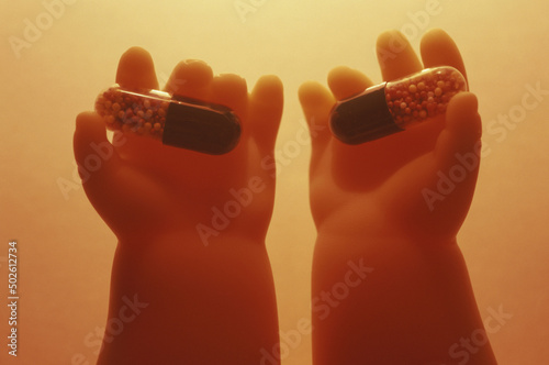 Close-up of capsules in a doll's hands photo