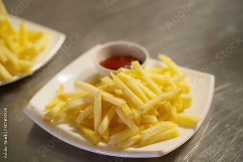 French fries on a white plate with ketchup