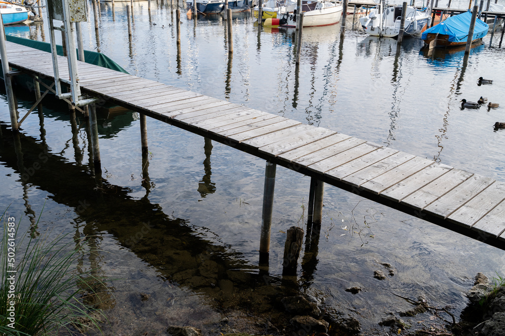 Wooden jetty without rallings in the morning in the lake Wooden jetty without rallings in the morning in the lake