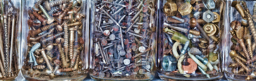 Close-up of nuts and bolts with screws and nails in jars photo