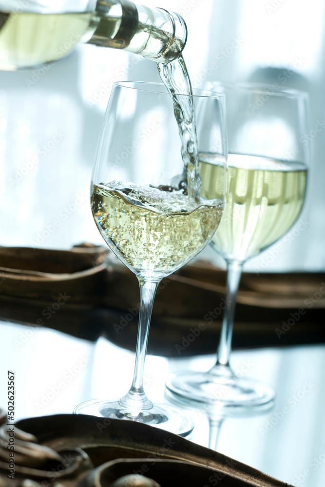 White wine being poured into a wine glass White wine being poured into a wine glass