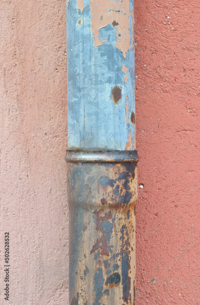 Close Up of Old Metal Rainwater Pipe against Pink Painted Cement Wall Close Up of Old Metal Rainwater Pipe against Pink Painted Cement Wall