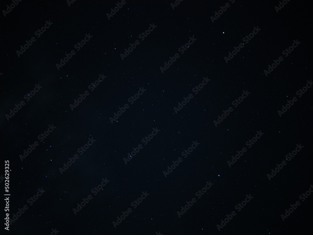 Adorable astrology and astronomy space background Long exposure photo of clear dark blue and black starry night sky filled with a lot of tiny white dot like small shiny bright stars constellation.