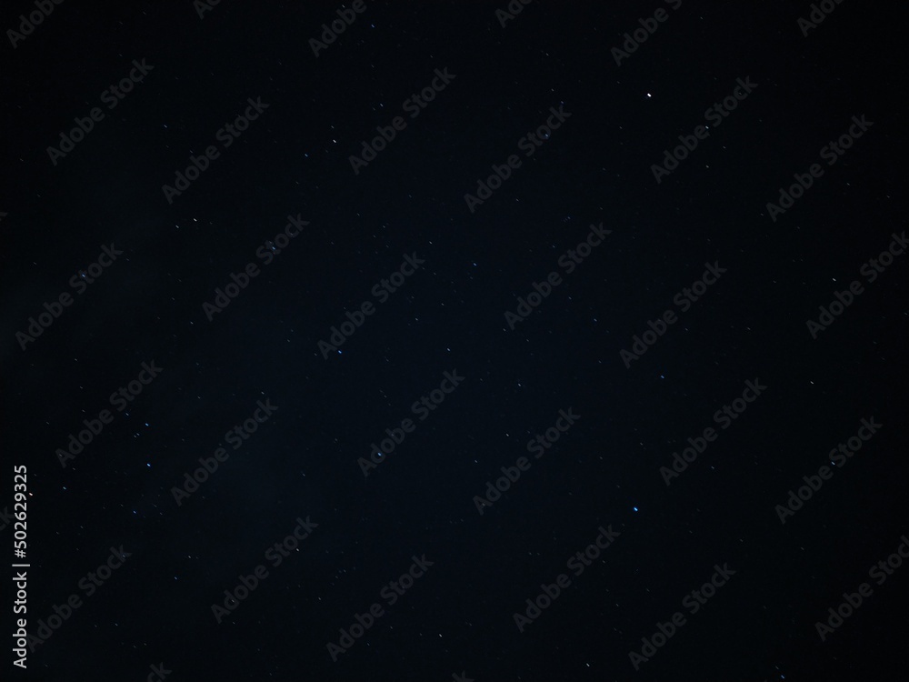Fototapeta premium Adorable astrology and astronomy space background Long exposure photo of clear dark blue and black starry night sky filled with a lot of tiny white dot like small shiny bright stars constellation.