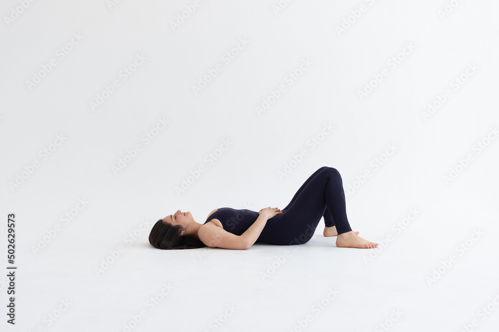 Sporty young woman doing yoga practice isolated on white background. Concept of healthy life and natural balance between body and mental development. Full length