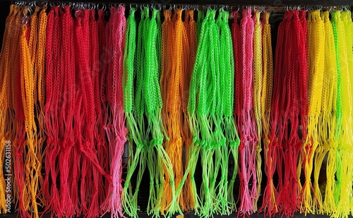 Bunch of spirals and twisted thick colorful multicolor rainbow nylon and polyester plant pot hanging thread, cords, or ropes stacked together. Beautiful Horizontal closeup detail macro side view.