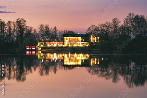 Calm evening at a lake with illuminated hotel