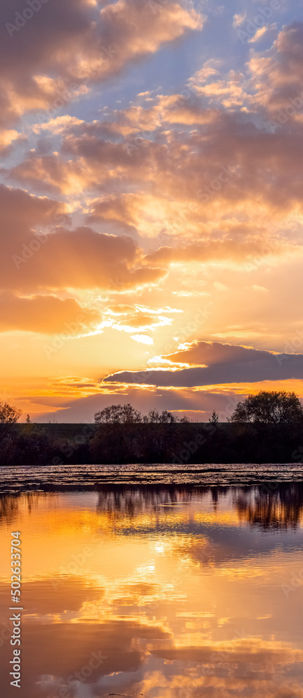 Sunset on the river, picturesque cloudy sky reflected in the water Sunset on the river, picturesque cloudy sky reflected in the water