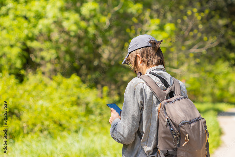 Male backpacker consults his mobile device to search for a route, travel concept.