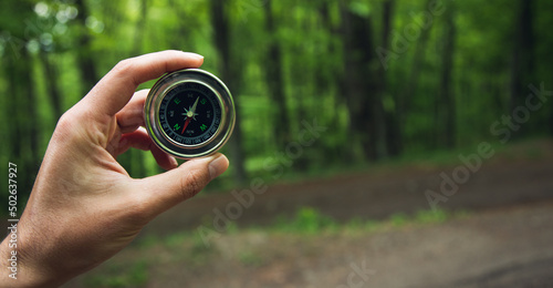 Compass in man hand in forest