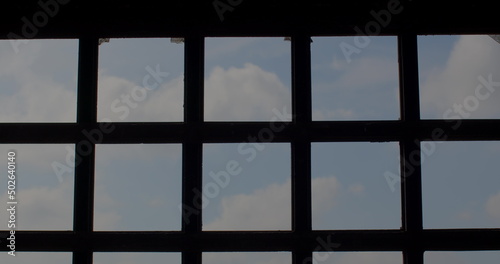 The movement of the black metal bars of the prison against the blue sky. Natural light and air in the restriction of freedom. Organize windows to let light and air into the room.