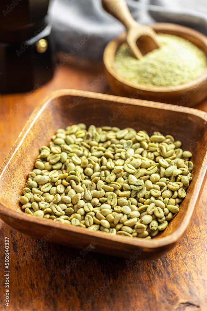 Unroasted green coffee beans in wooden bowl. Unroasted green coffee beans in wooden bowl.