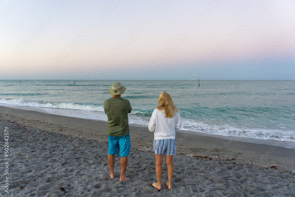 Retired couple on beach at sunrise in Florida