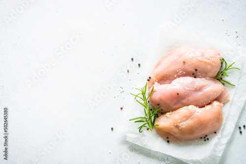 Canvas Print Chicken fillet with spices and herbs at whhite stone table
