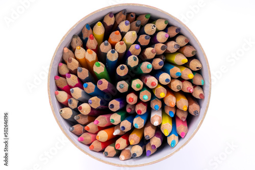 colored pencils in a round box on a white background photo