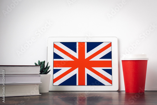 Foto UK flag, textbooks, a cup of hot drink coffee or tea on the table, the concept o