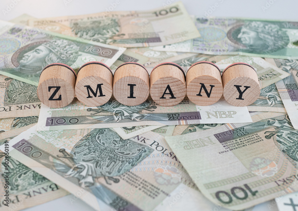Word "zmiany" written in polish with wooden blocks standing on money, "zmiany" means "changes" - obrazy, fototapety, plakaty 