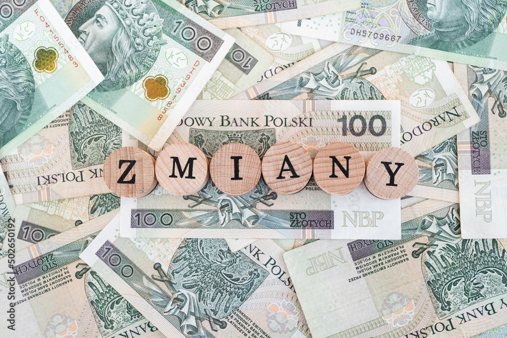 Word "zmiany" written in polish with wooden blocks standing on money, "zmiany" means "changes" - obrazy, fototapety, plakaty 