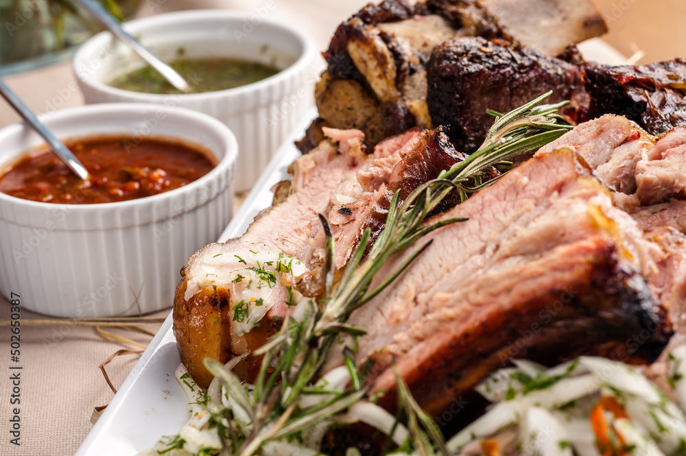 Grilled pork ribs with rosemary and sauces. Pork ribs BBQ. The large plate of meat. Roast pork Grilled pork ribs with rosemary and sauces. Pork ribs BBQ. The large plate of meat. Roast pork