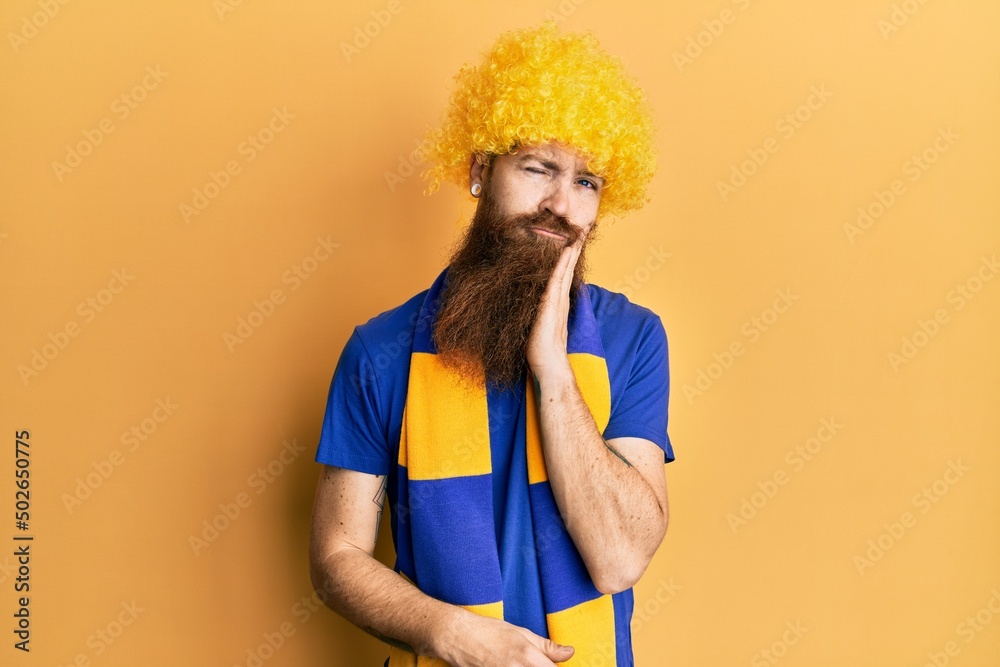 Redhead man with long beard football hooligan cheering game wearing funny wig thinking looking tired and bored with depression problems with crossed arms. Redhead man with long beard football hooligan cheering game wearing funny wig thinking looking tired and bored with depression problems with crossed arms.