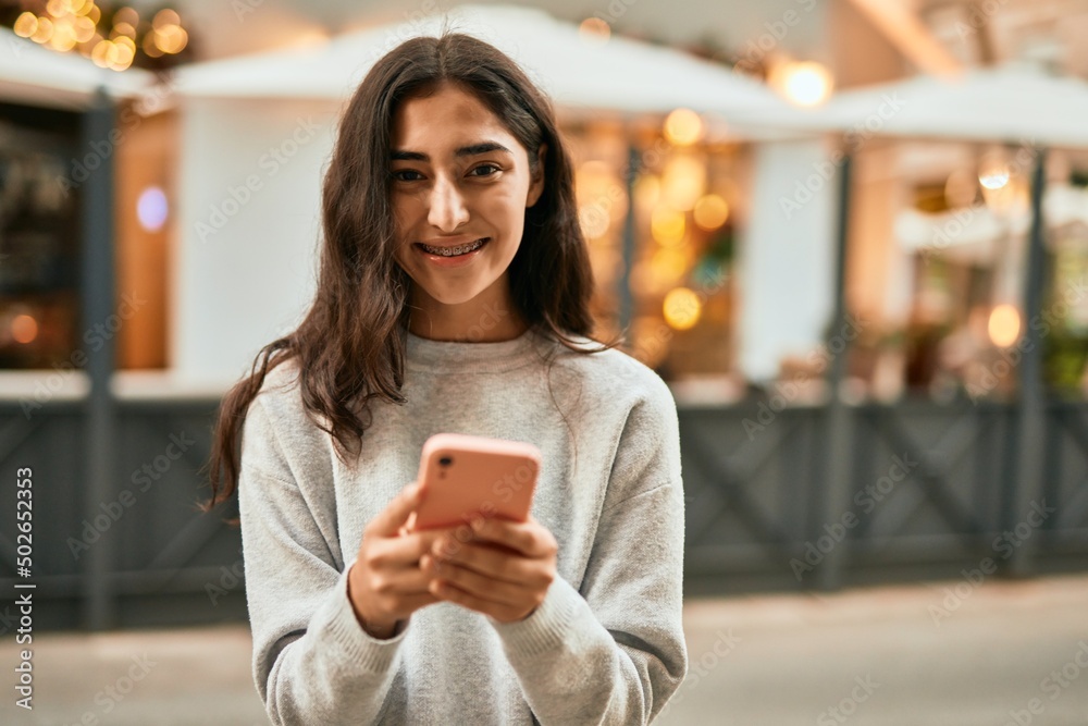 Young middle east girl smiling happy using smartphone at the city.