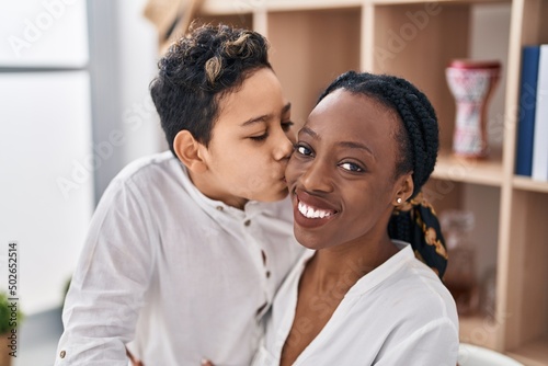 African american mother and son hugging each other and kissing sitting on table at home © Krakenimages.com
