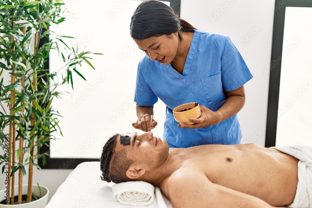 Latin man reciving facial treatment at beauty center. Latin man reciving facial treatment at beauty center.
