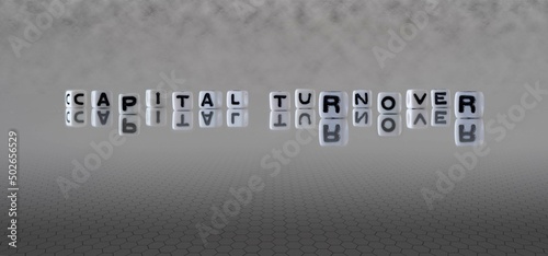 capital turnover word or concept represented by black and white letter cubes on a grey horizon background stretching to infinity