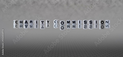 charity commission word or concept represented by black and white letter cubes on a grey horizon background stretching to infinity