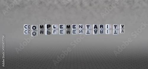 complementarity word or concept represented by black and white letter cubes on a grey horizon background stretching to infinity