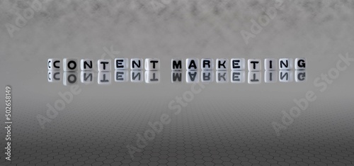 content marketing word or concept represented by black and white letter cubes on a grey horizon background stretching to infinity