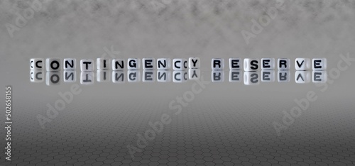 contingency reserve word or concept represented by black and white letter cubes on a grey horizon background stretching to infinity photo