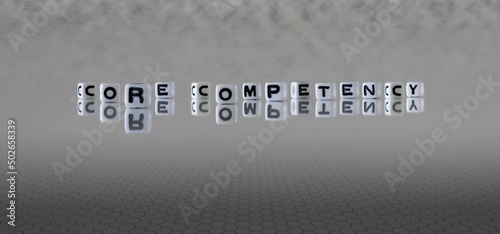 core competency word or concept represented by black and white letter cubes on a grey horizon background stretching to infinity photo