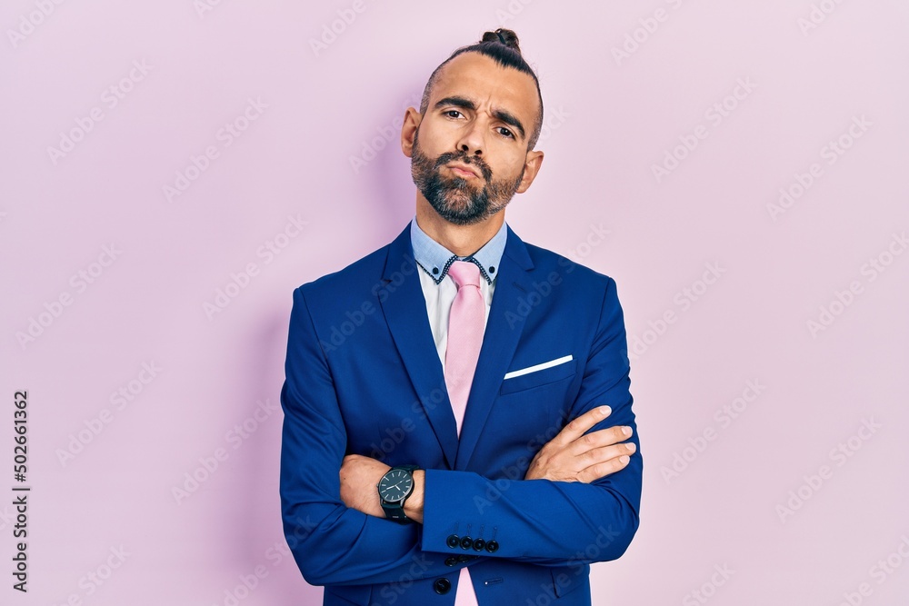 Young hispanic man wearing business suit with arms crossed gesture looking at the camera blowing a kiss being lovely and sexy. love expression. Young hispanic man wearing business suit with arms crossed gesture looking at the camera blowing a kiss being lovely and sexy. love expression.