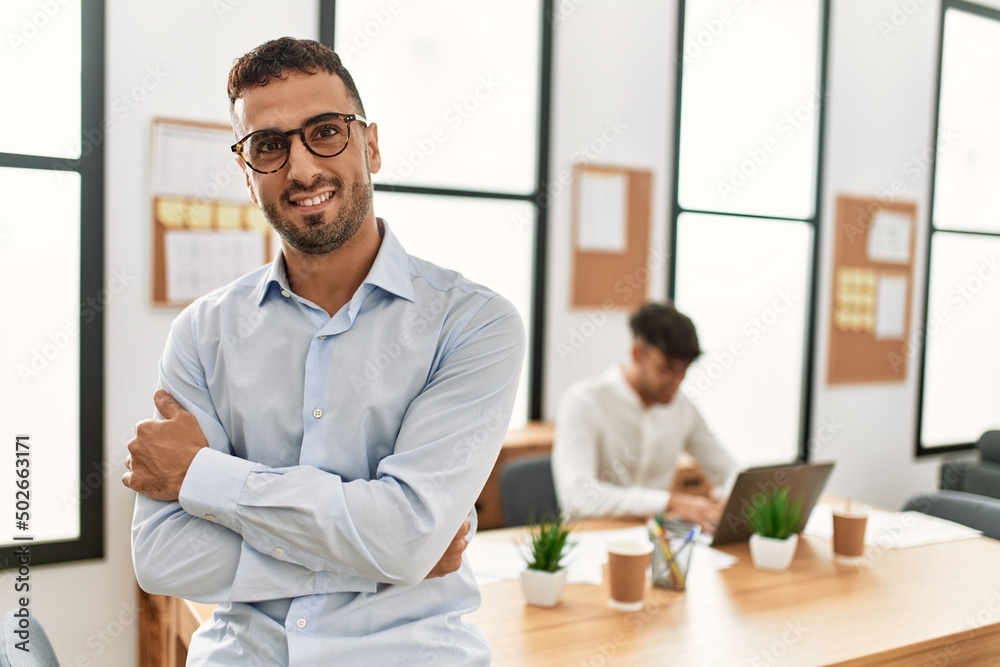Two hispanic men business workers standing with arms crossed gesture at office Two hispanic men business workers standing with arms crossed gesture at office