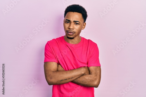 Young african american man wearing casua t shirt skeptic and nervous, disapproving expression on face with crossed arms. negative person.