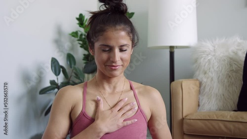 Beautiful woman in tank top holds hand over heart during meditation slow motion 8K