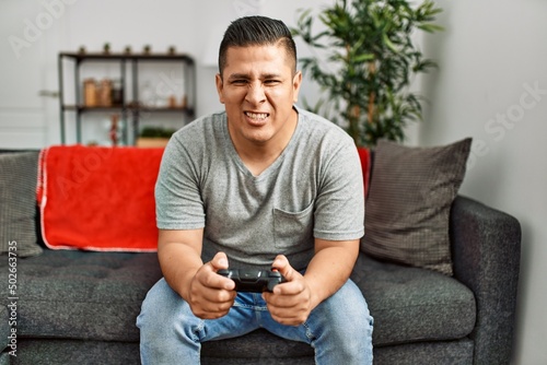 Young hispanic man angry playing video game at home. © Krakenimages.com